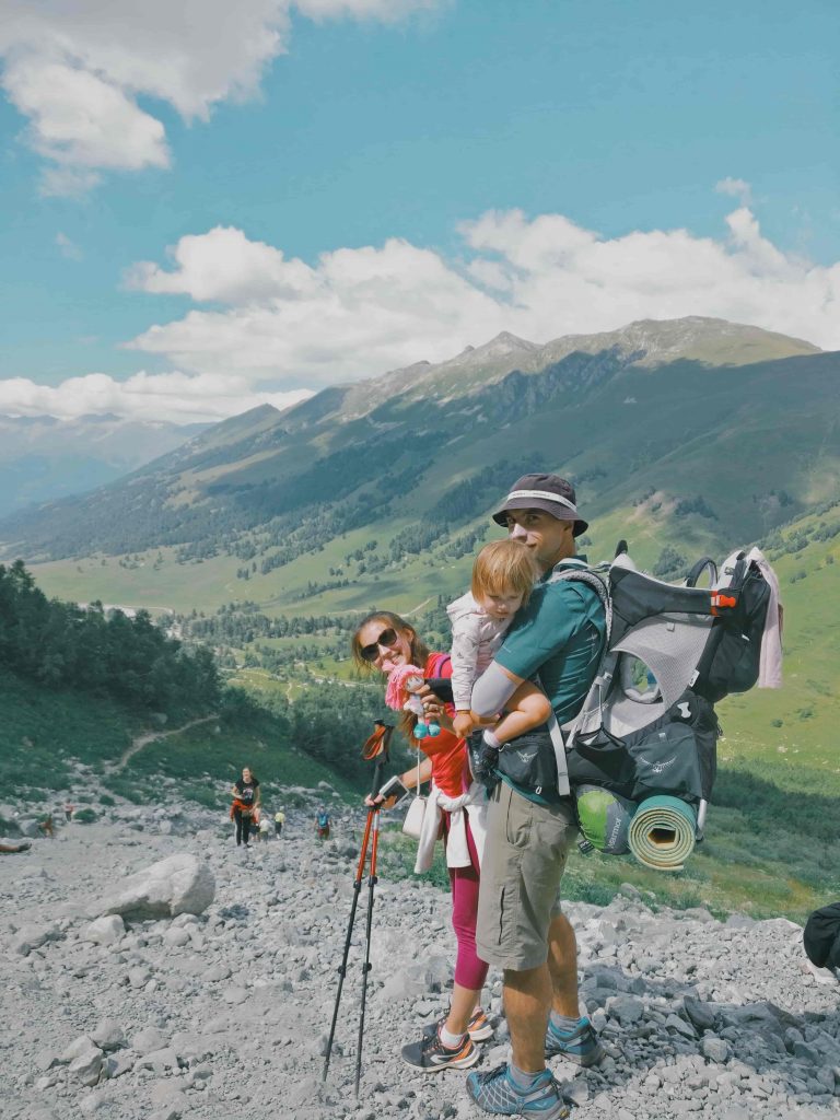 A couple with their young child hiking in the mountains. 